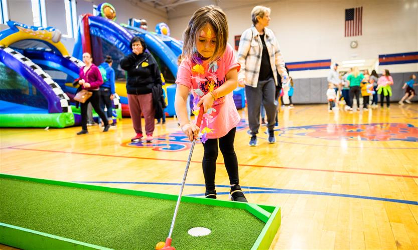 A girl plays mini golf